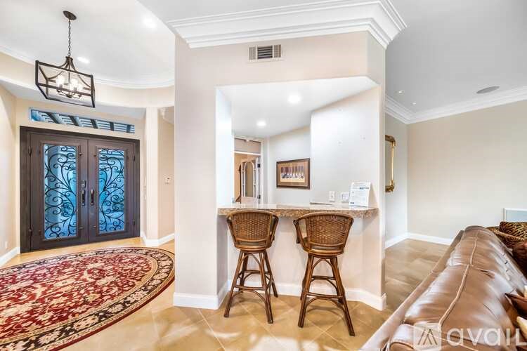 A living room with a brown leather couch and a rug.