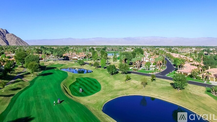 A golf course with a green and a blue water hole.