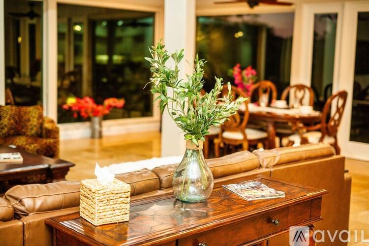 A table with a vase of flowers and a tissue box on it.