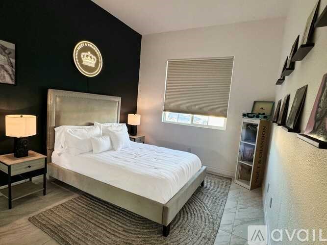 A bedroom with a large bed and a lamp on a side table.