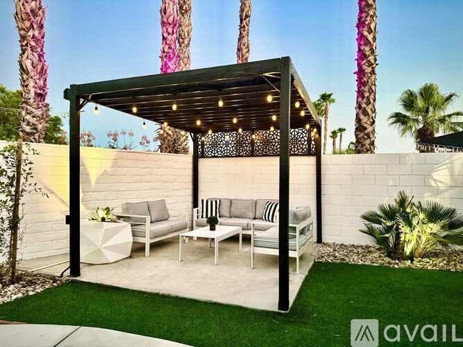 A patio area with a white couch and a black and white striped pillow.