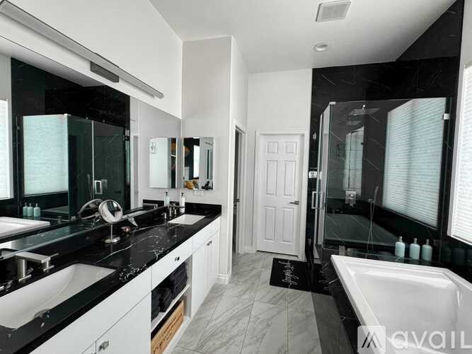 A bathroom with a black countertop and white fixtures.