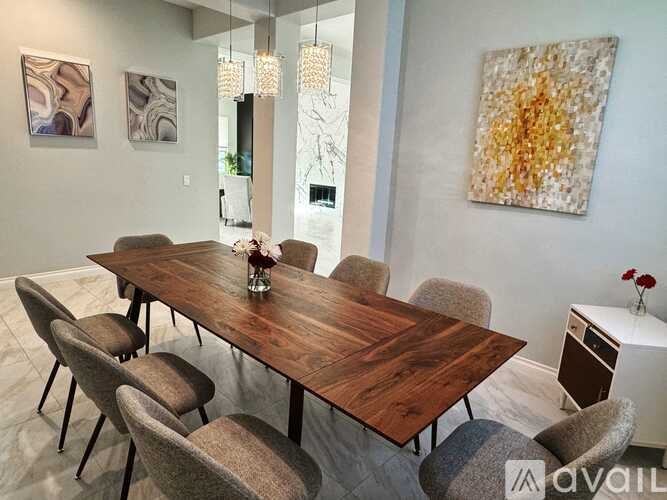 A wooden dining table surrounded by chairs in a room.