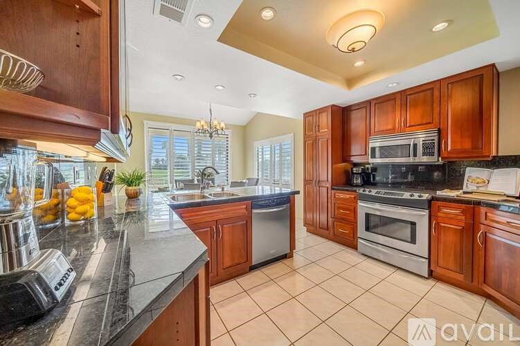 A kitchen with wooden cabinets and a black countertop.