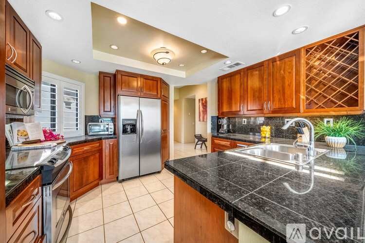 A kitchen with wooden cabinets and a black countertop.