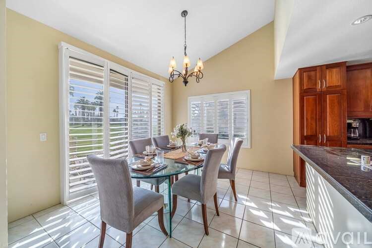A dining room with a glass table and chairs.