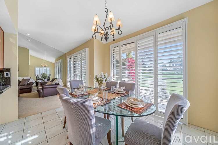 A dining room with a glass table and chairs.