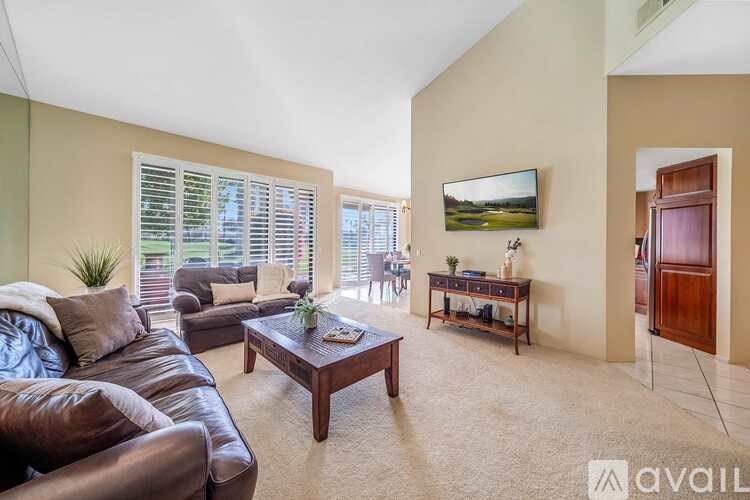 A living room with a brown leather couch and a wooden coffee table.