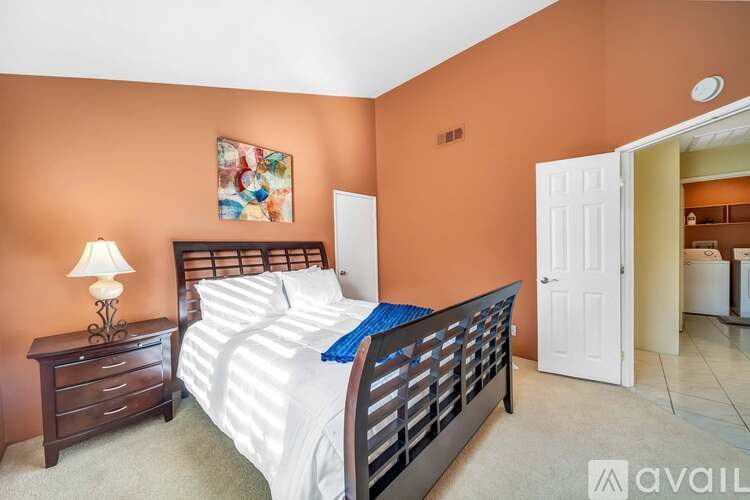 A bedroom with a bed, nightstand, and lamp.