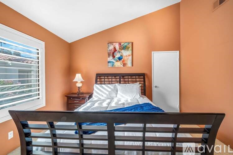 A bedroom with a bed, nightstand, and window.