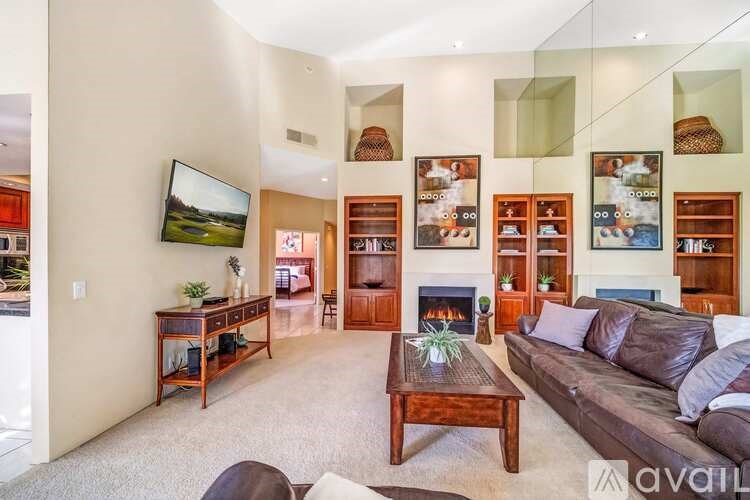 A living room with a couch, coffee table, and a television.