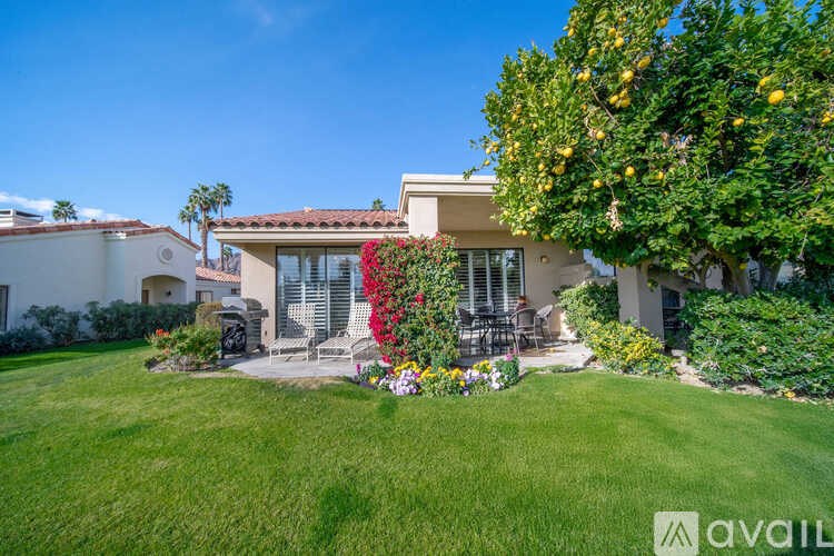 A house with a well-kept lawn and a lemon tree in front.