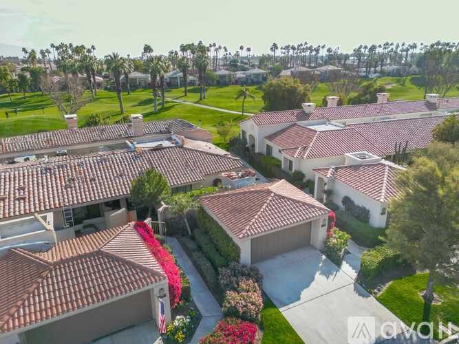 A row of houses with red tile roofs are shown from an aerial perspective.