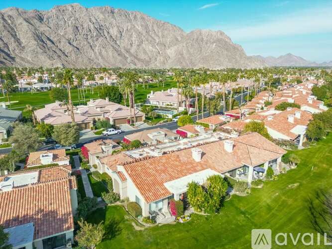A bird's eye view of a residential area with houses and palm trees.