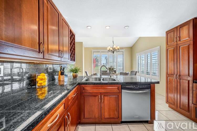 A kitchen with wooden cabinets and a black countertop.