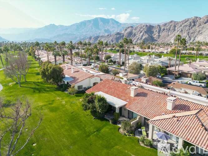 A bird's eye view of a neighborhood with houses and palm trees.
