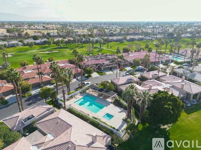 A bird's eye view of a neighborhood with houses and a pool.