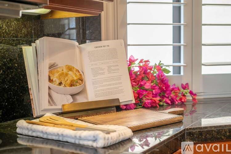 A book with a recipe for chicken pie is open on a kitchen counter.