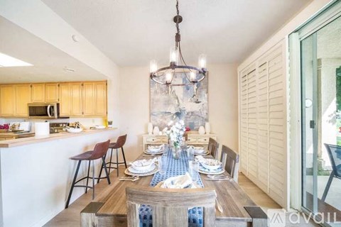 A dining room with a table set for a meal.