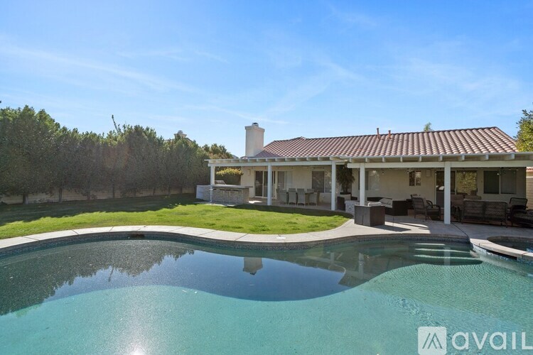 A house with a pool in front of it.