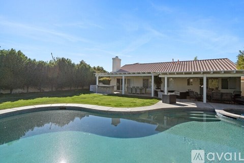 A house with a pool in front of it.