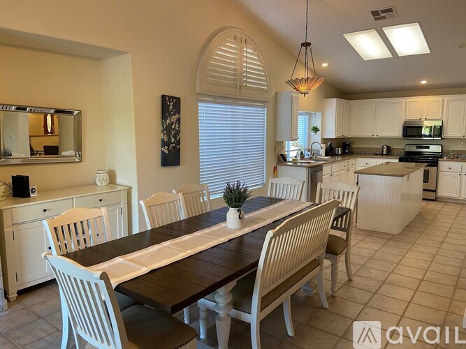A dining room with a long table and chairs.
