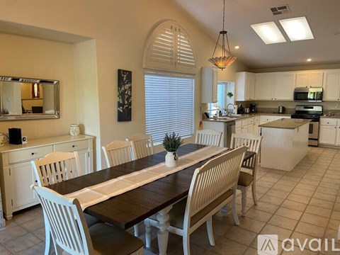 A dining room with a long table and chairs.
