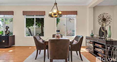 A dining room with a wooden table and chairs.