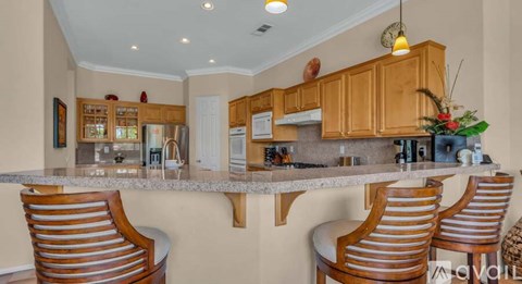 A kitchen with wooden cabinets and a marble countertop.
