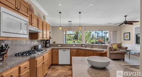 A kitchen with wooden cabinets and a marble countertop.