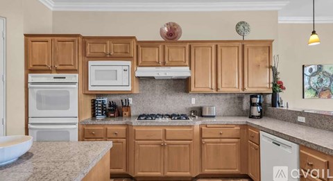 A kitchen with wooden cabinets and granite countertops.