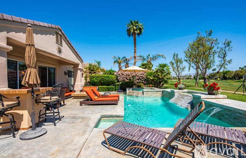 A poolside patio with a table and chairs.