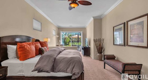 A bedroom with a large bed and a ceiling fan.