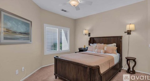 A bedroom with a large bed and a painting on the wall.