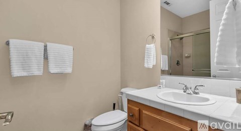 A bathroom with a toilet, sink, and towel rack.