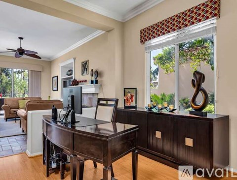 A living room with a brown wooden table and chairs.
