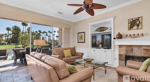 A living room with a brown couch and a fireplace.