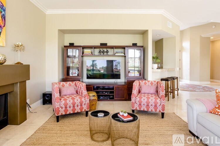A living room with a fireplace and two chairs.