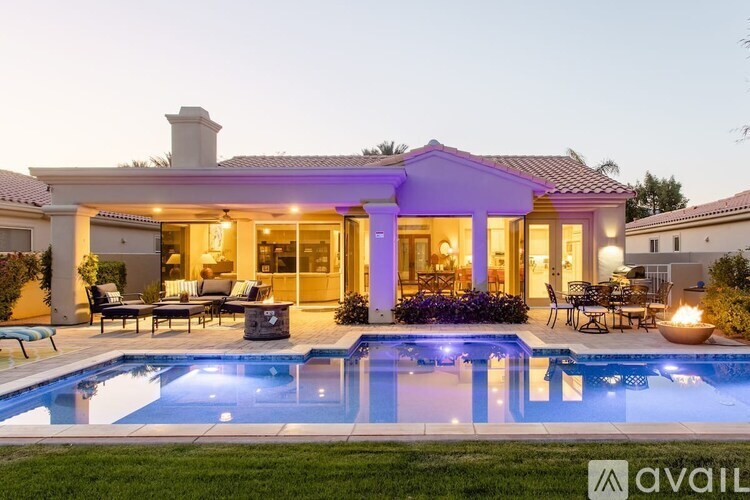 A house with a purple roof and a pool in front.