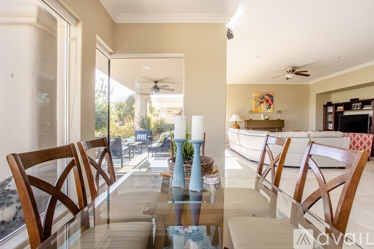 A modern dining room with a glass table and chairs.