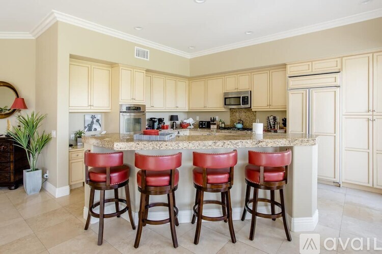 A kitchen with a bar area featuring a counter and four stools.
