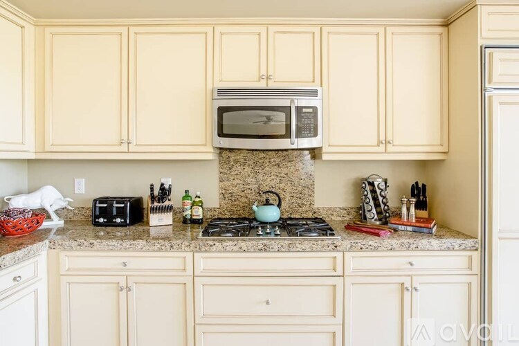 A kitchen with a granite countertop and wooden cabinets.