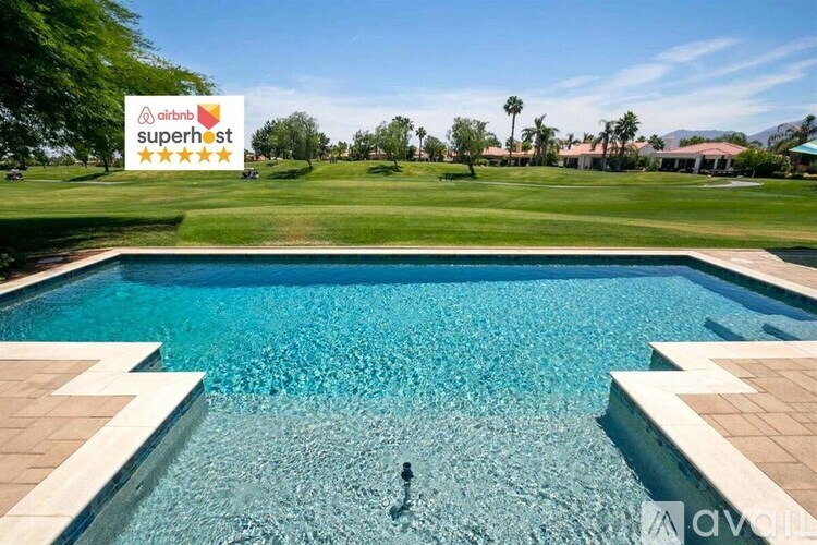 A person is swimming in a pool with a sign that says "airbnb superhost" in the background.