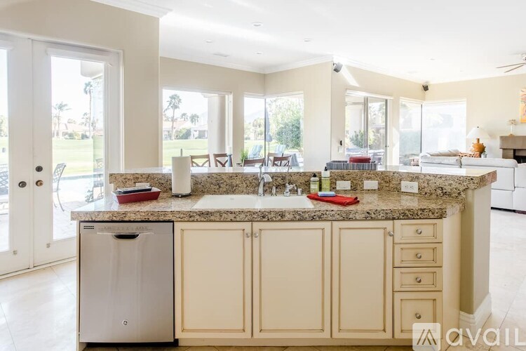 A kitchen with a granite countertop and a dishwasher.