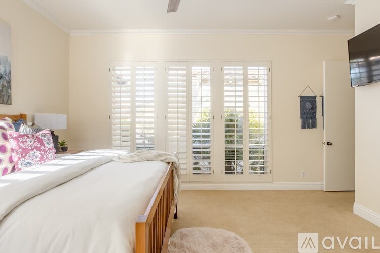 A bedroom with a large bed and sliding glass doors.