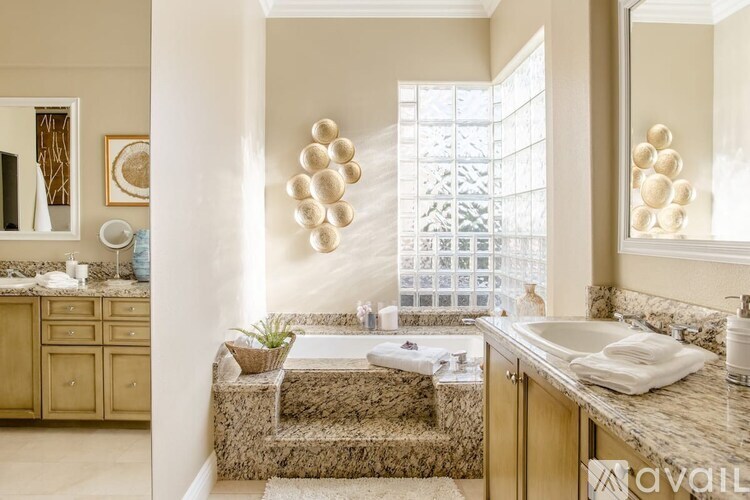 A bathroom with a large window, a sink, and a bathtub.