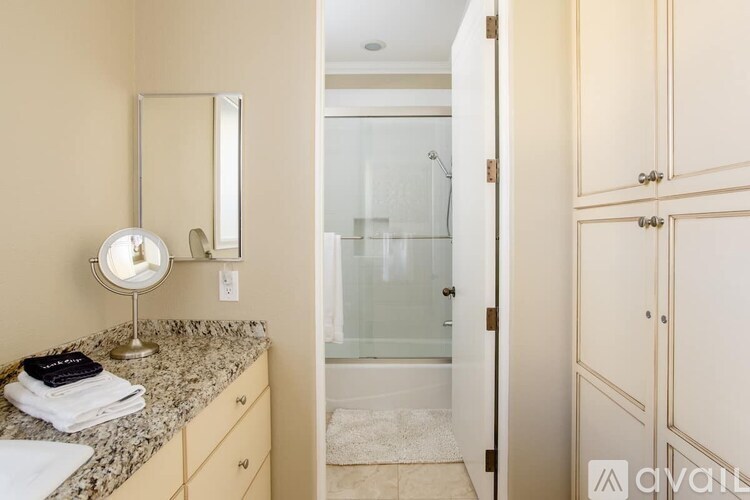 A bathroom with a vanity, mirror, and a glass shower door.