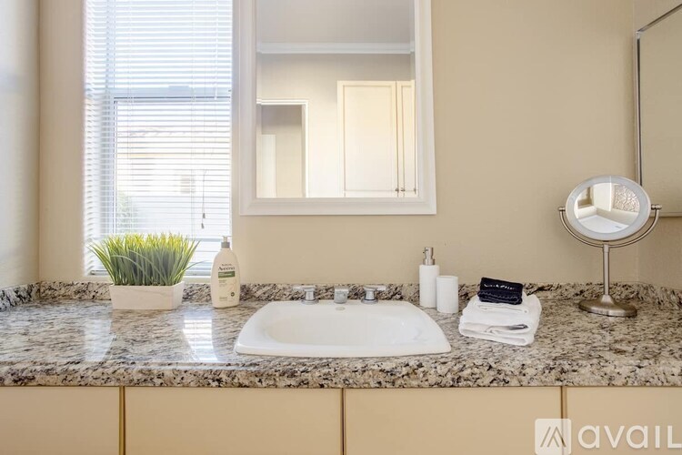 A bathroom with a marble countertop and a white sink.