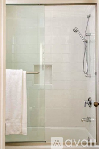 A white towel hangs on a glass door.