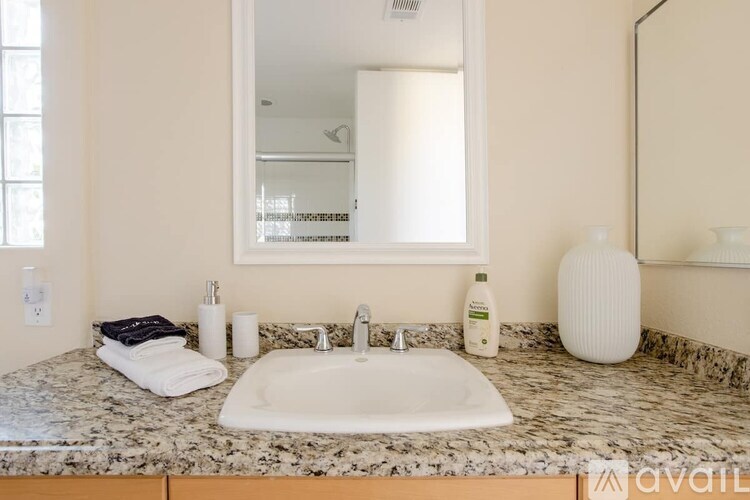 A bathroom with a marble countertop and a white sink.